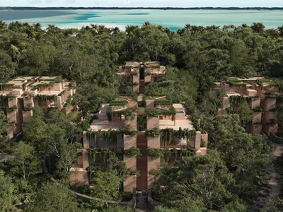 Aerial view of Aldea Kalan jungle residences nestled between tropical forest and Bacalar Lagoon