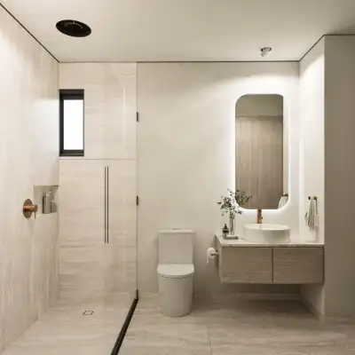 Modern bathroom with a glass shower enclosure, backlit vanity mirror, and light wood cabinetry at Atzaro Residences, Playa del Carmen