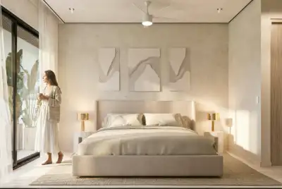 Bedroom with a distinctive curved white wall, balcony access, and soft neutral decor at Atzaro Residences, Playa del Carmen