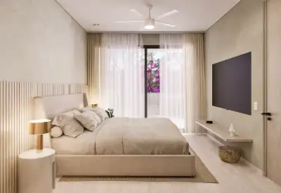 Bedroom with neutral tones, wall-mounted TV, and sliding glass doors opening to a balcony at Atzaro Residences, Playa del Carmen