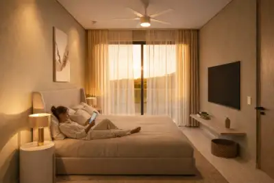 Bedroom bathed in warm golden-hour light with soft textiles and a serene atmosphere at Atzaro Residences, Playa del Carmen