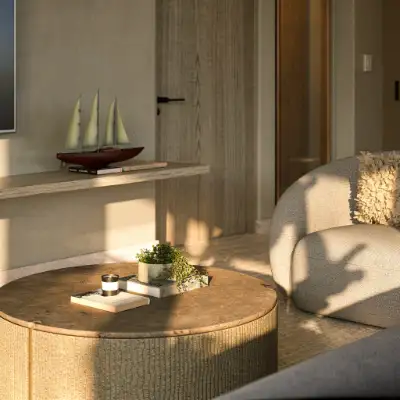 Cozy living area with a round woven coffee table, white sofa, and soft natural lighting at Atzaro Residences, Playa del Carmen