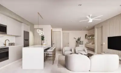 Open-concept living room and kitchen with all-white interiors, curved sofa, and minimalist design at Atzaro Residences, Playa del Carmen