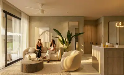 Warmly lit open-concept living and kitchen area with soft neutral tones and ambient lighting at Atzaro Residences, Playa del Carmen