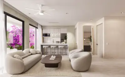 Living room with a curved white sofa, marble coffee table, and views of purple bougainvillea outside at Atzaro Residences, Playa del Carmen