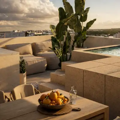 Rooftop pool lounge area at golden hour with plush seating, dining space, and city views at Atzaro Residences, Playa del Carmen