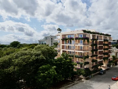 Vista de calle del exterior de la residencia Idilik con arquitectura wellness contemporánea en Playa del Carmen