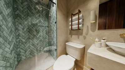 Baño con pared de mármol verde en Maia, Playa del Carmen