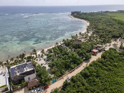 Aerial view of the Tulum coastline where jungle meets beach and turquoise Caribbean Sea