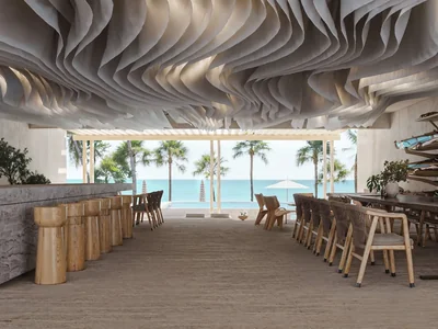 Beach club interior with undulating wooden ceiling and natural materials at Maranta Tulum