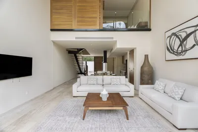 Living room with double-height mezzanine at Mistiq Villas, Tulum