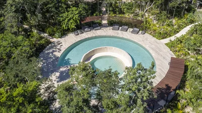 Aerial view of circular cenote pool at Mistiq Temple, Tulum