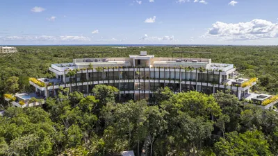 Aerial view of curved building in jungle at Mistiq Temple, Tulum