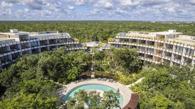 Aerial view of curved complex in jungle at Mistiq Temple, Tulum