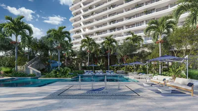 Pool with palm trees and towers at Nautica Residences, Cancun