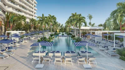 Resort pool deck with palm trees and loungers at Nautica Residences, Cancun