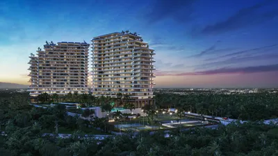 Twin towers at dusk with jungle backdrop at Nautica Residences, Cancun