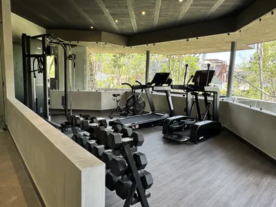 Jungle gym and fitness center with natural stone walls and tropical vegetation at Siwa Elevé in Tulum