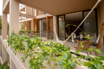 Balcón con hamaca y vegetación en The Village Resort & Residences en Corasol, Playa del Carmen