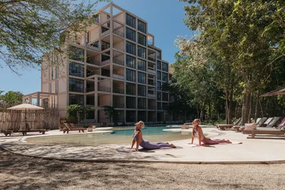 Deck de alberca con camastros en The Village Resort & Residences en Corasol, Playa del Carmen