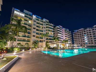 Night view of Valle Aurora pool with residence exterior illuminated in Playa del Carmen, Quintana Roo