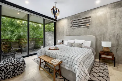 Bedroom with concrete walls and jungle view at Xalet Tulum