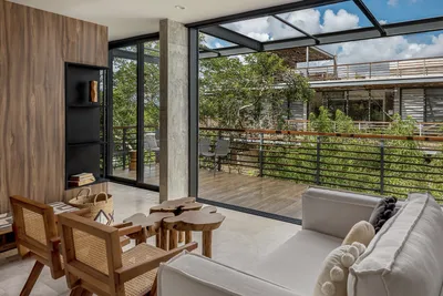 Dining and living area with balcony overlooking jungle at Xalet Tulum